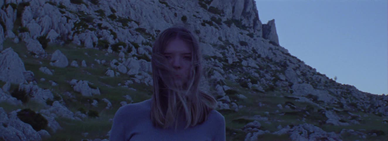 Young woman with blond hair in a mountain setting