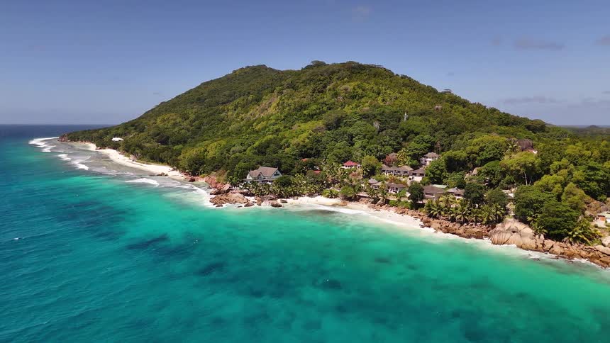 A tropical island with forested hills and turquoise coastline