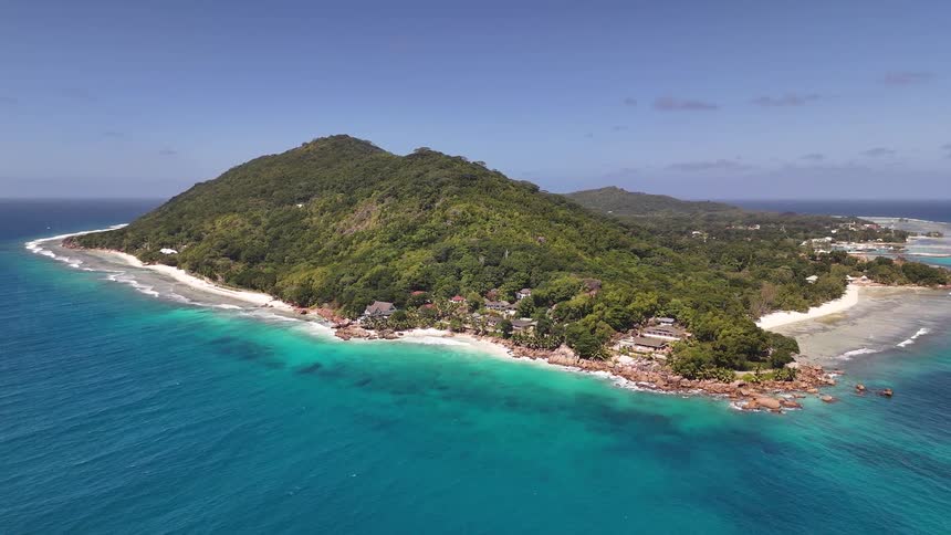A resort on a mountainous island is surrounded by green vegetation