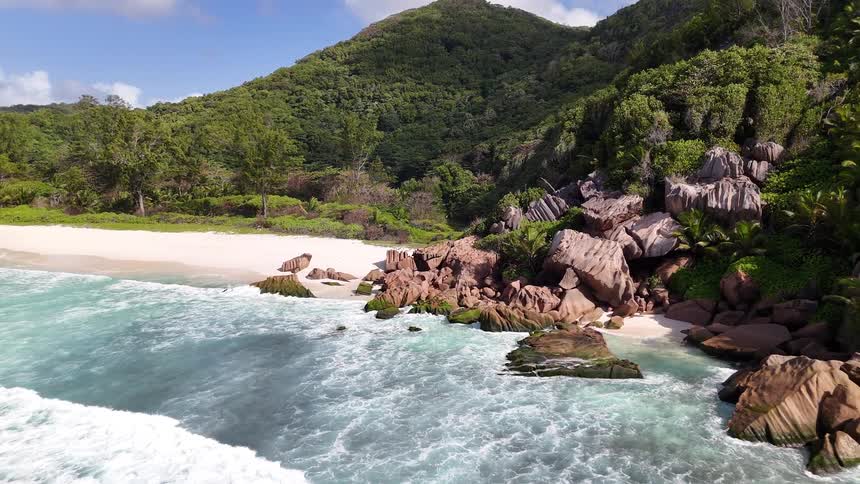 Small waves move and land on the sand and rocks