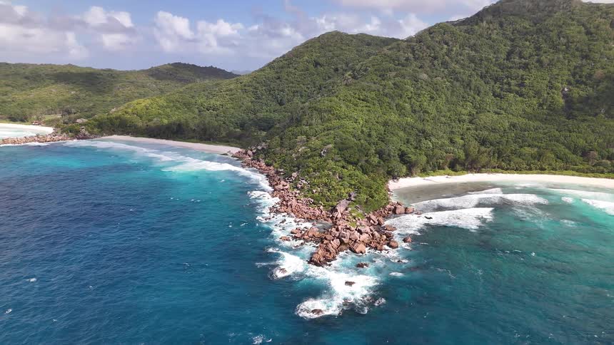 Peninsula with forested mountains on the edge of a turquoise sea