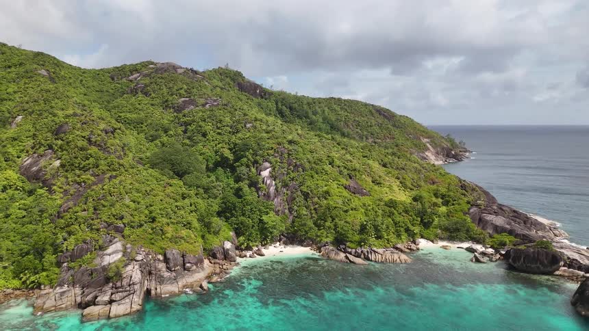 A mountainous highland is surrounded by the ocean at midday