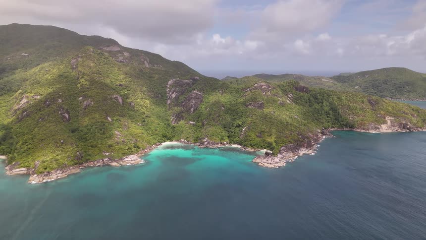 Vast blue sea on the edge of a greenish mountainous island