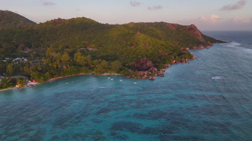 A mountainous island covered with vegetation with a small town in the midst