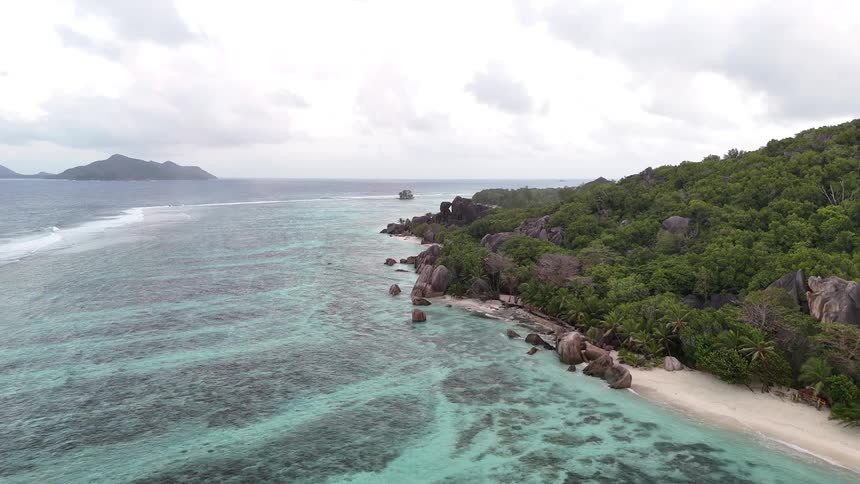 Landscape of a turquoise blue archipelago with the coast lined with tropical palm trees