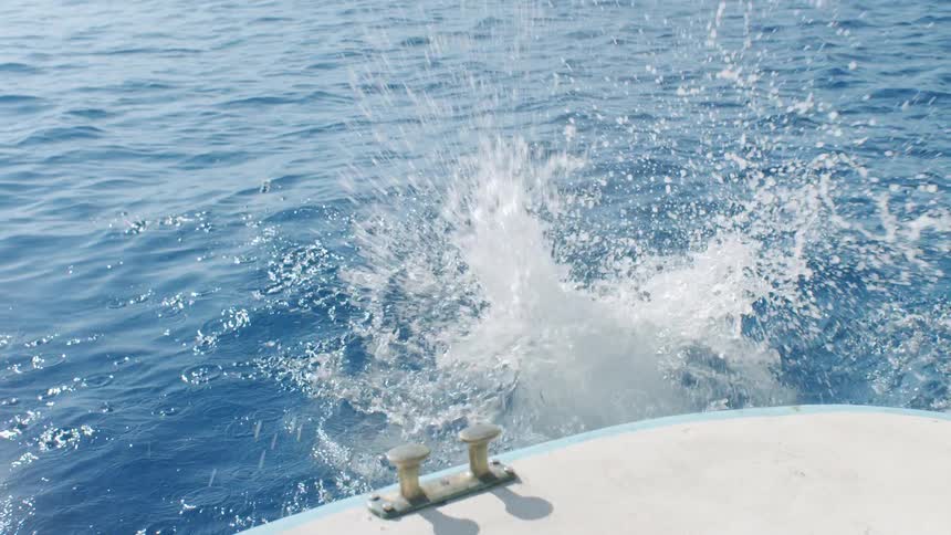Woman in white swimsuit jumping from yacht into sea