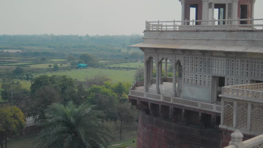 Large ornate building towers over the rural countryside on a foggy day