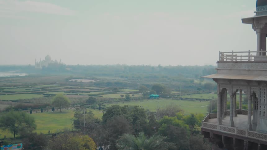 Historic building towers over the rural countryside while haze covers the landmark building on the horizon
