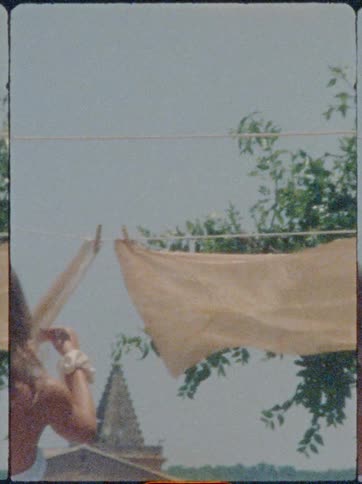Woman hanging clothes on a clothesline outdoors
