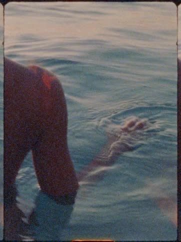 Woman in the sea at the end of the afternoon with the reflection of the sun