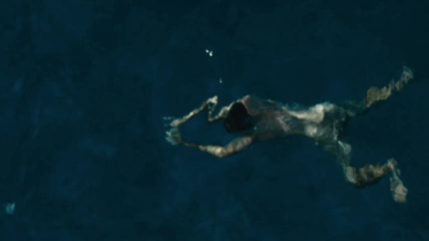Man in shorts swimming in the ocean