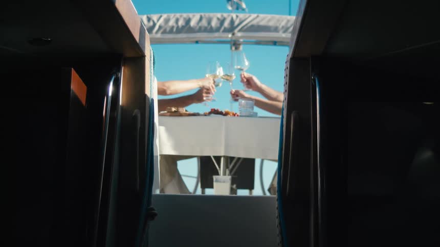 Four people toast their wine glasses outside