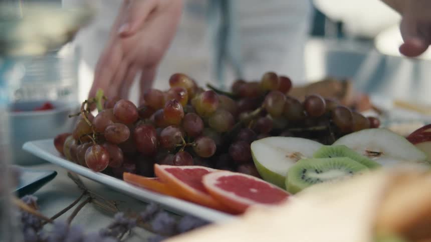 Setting down a platter of fruits on a table during an event
