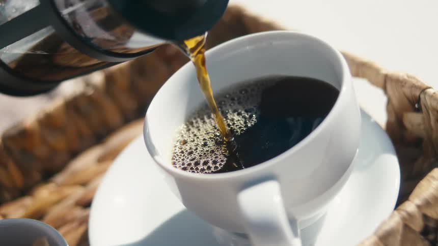Coffee is being poured into the cup