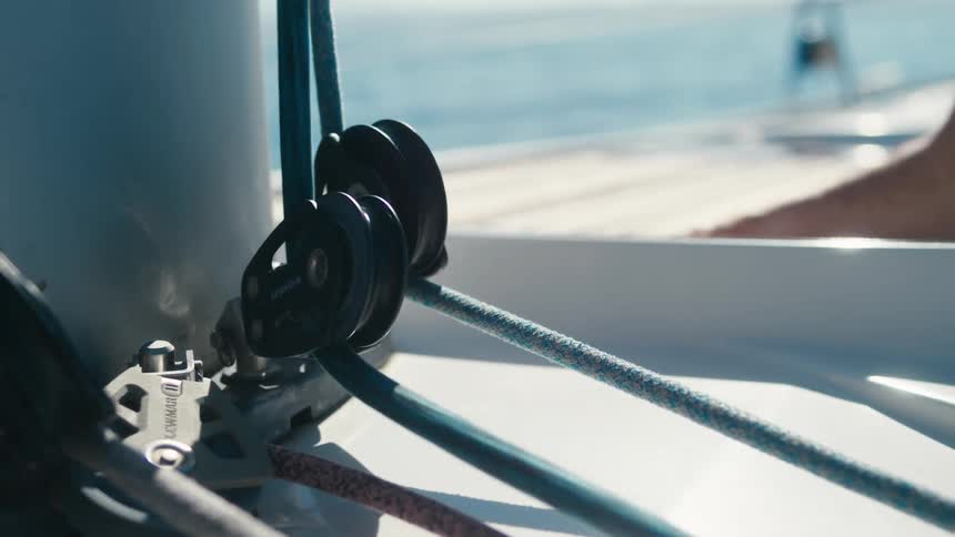 Closeup of a metal crank with a moving rope and a boat