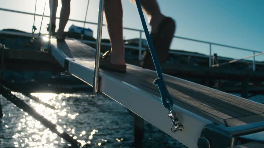 Two people crossing a ramp and heading towards a pier