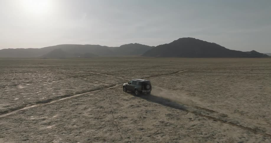 The truck is driving through the desert
