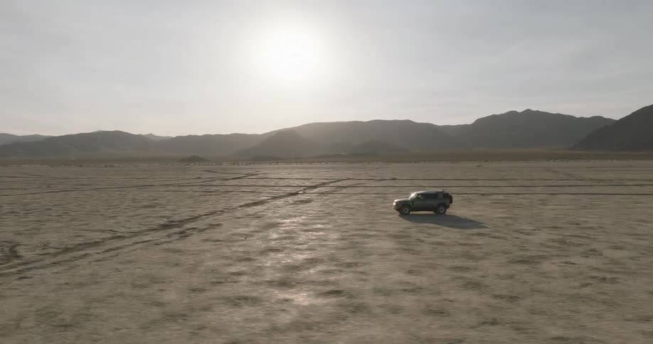 The vehicles drives in the desert on a sunny day