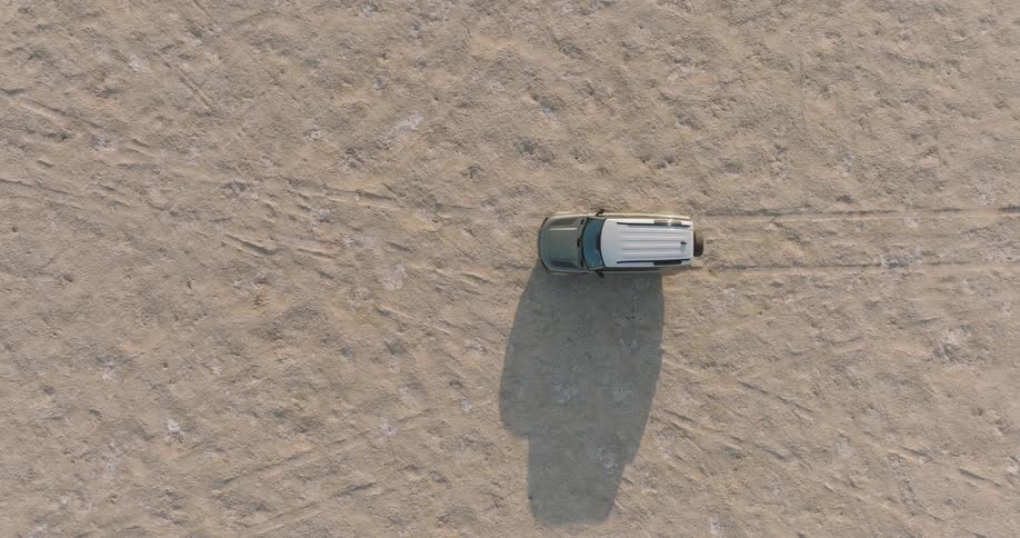 Sports utility vehicle drives through the desert leaving tracks on the ground