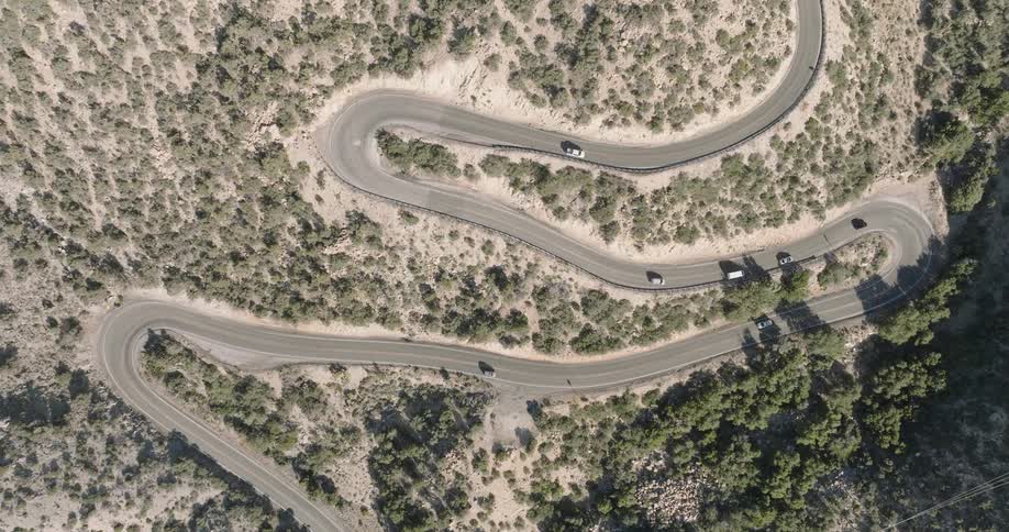 Aerial view of a winding road with vehicle traffic in the mountains
