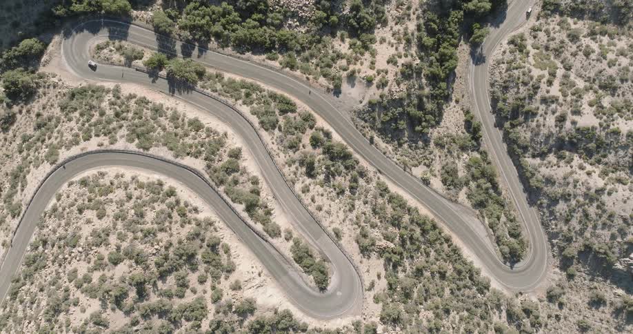 Aerial view of a winding road with vehicle traffic in a mountainous area