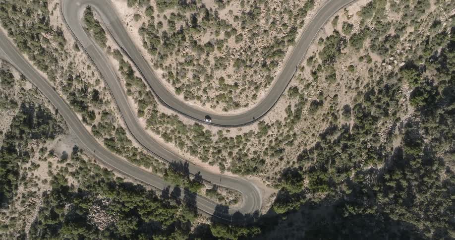 The cars drive on the winding road