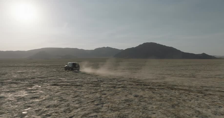 The truck is driving off road and leaving a dust cloud