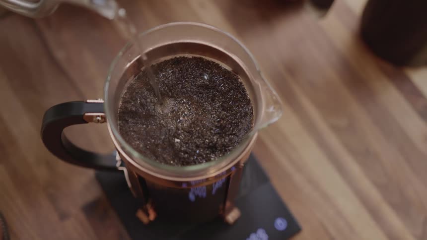 Water is being poured into a mug of coffee