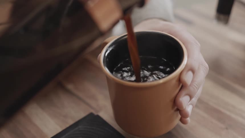 Woman pours a cup of coffee