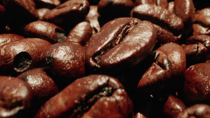 A pile of coffee beans are under a light