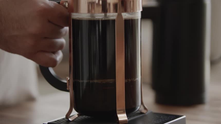 A persons hand holding a coffee cup