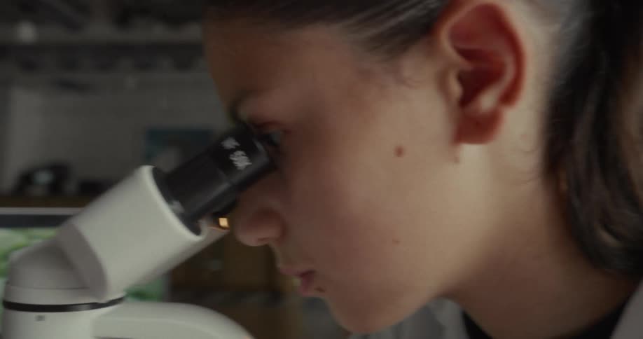 Young woman concentrating on a microscope