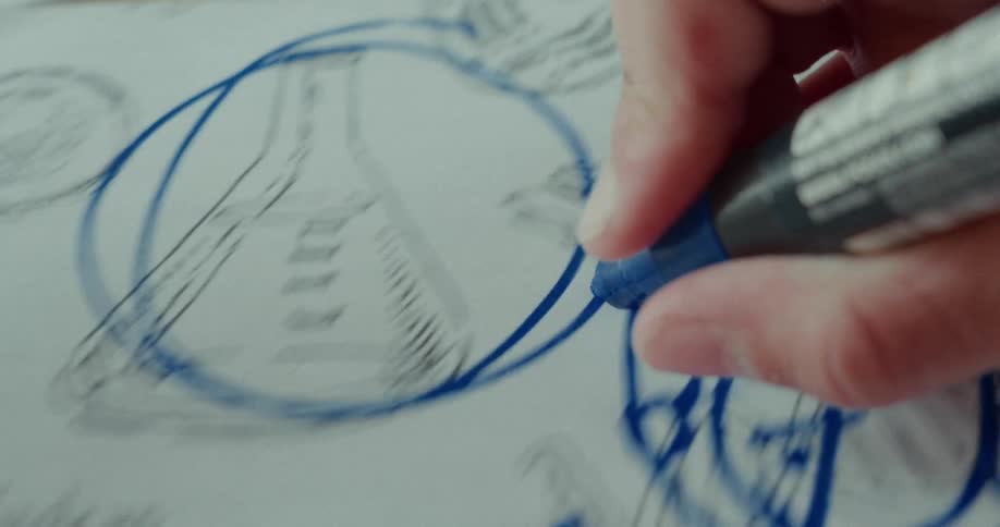A hand holding a marker circles a drawing of a beaker