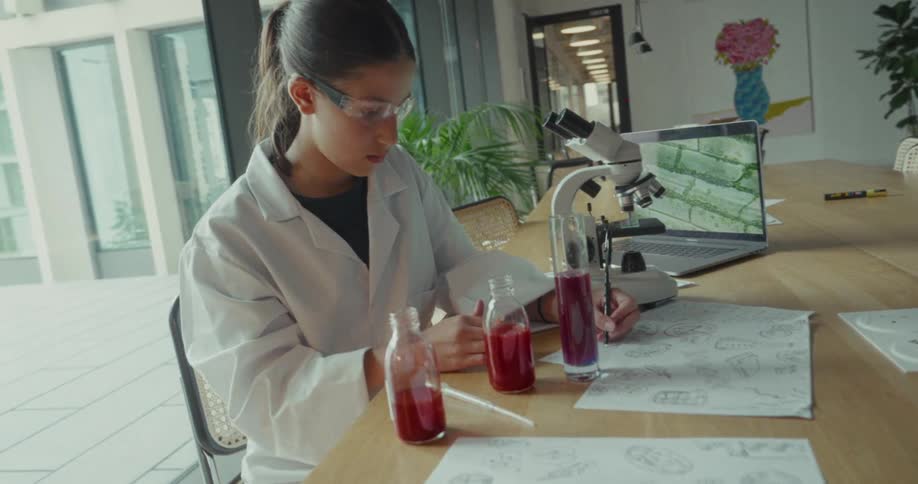 Young female scientist makes notes on a table in a lab during research