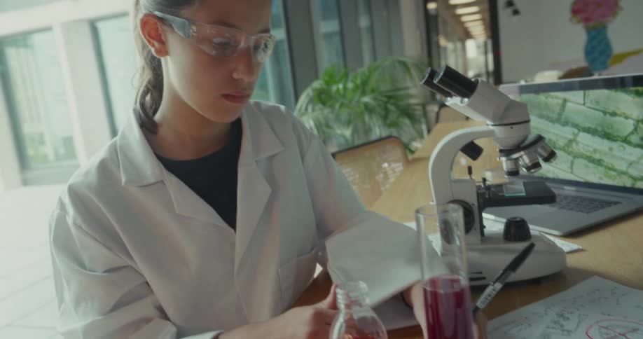 The girl draws with a pen in the lab