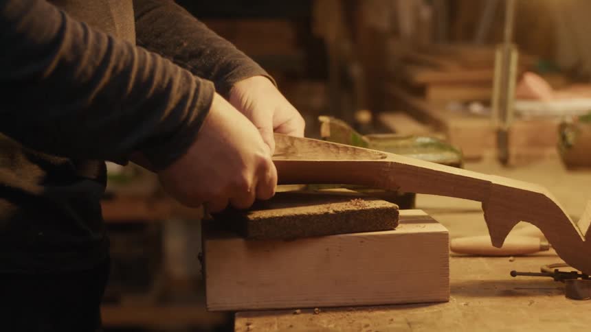 Pair of hands carving a piece of wood