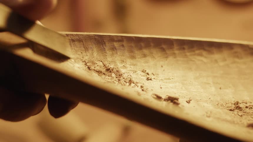 Wooden container being carved with a small tool