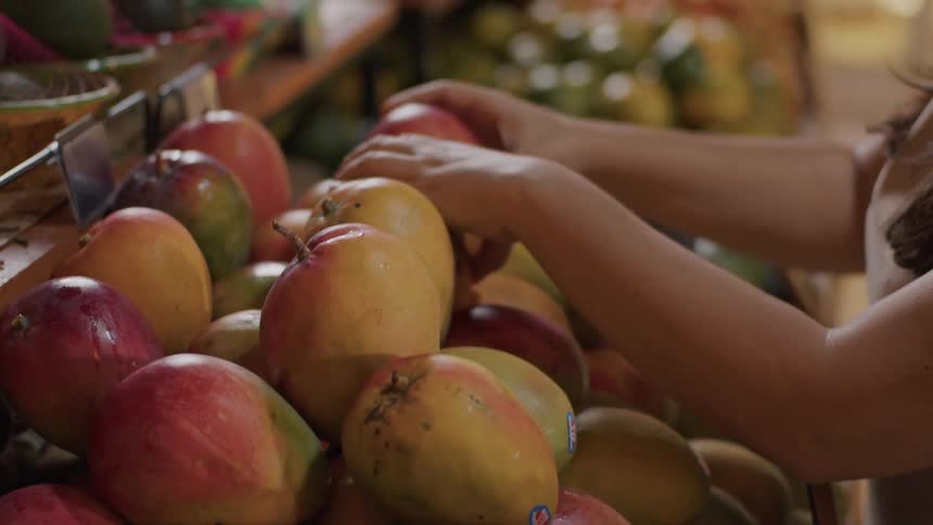 A person organizes fruits atmarket stall