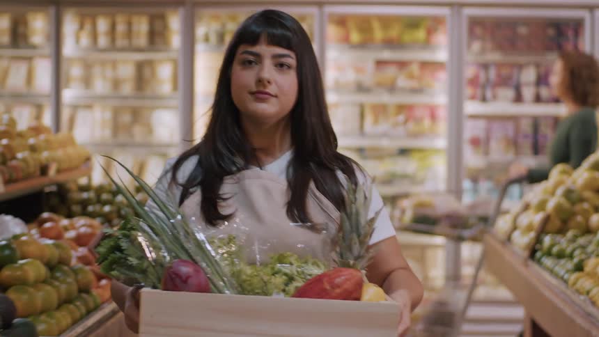 A woman shops for fresh produce inside a grocery store
