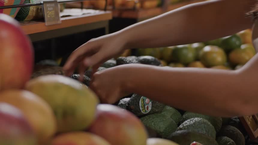 The worker fixes the stacks of produce on the stands