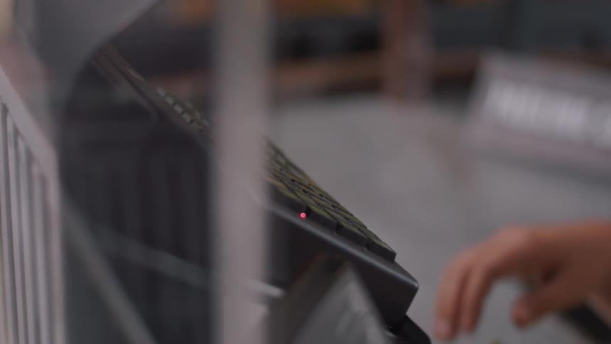 A person enters product bills on a keypad at a billing counter
