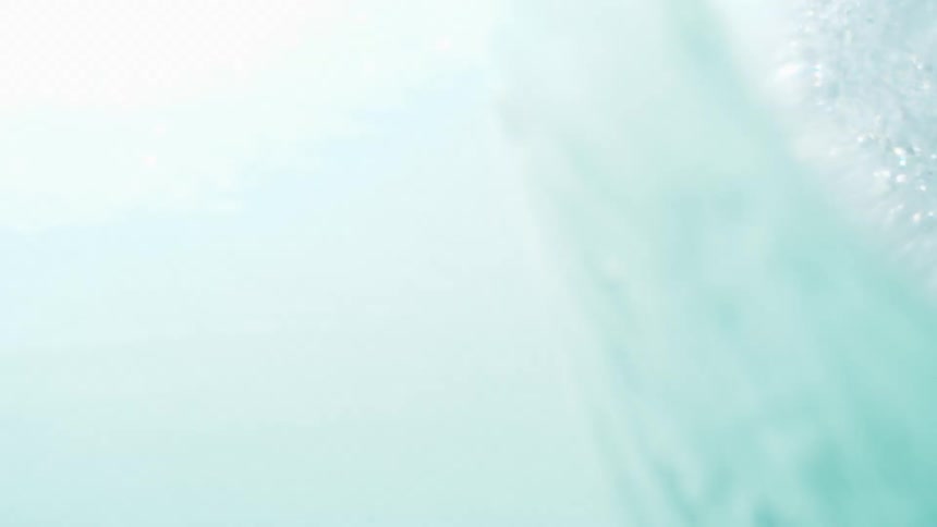 A closeup of a blue ocean with a large wave cresting and breaking from left to right the wave forms a distinct tube or barrel shape with white foam and spray visible as it crashes the sky above is a bright clear blue with a few scattered clouds