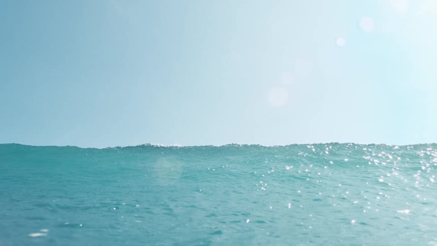 Light blue wave breaking in the ocean