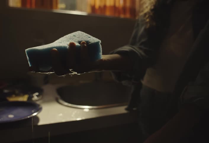 The woman is holding a dripping sponge