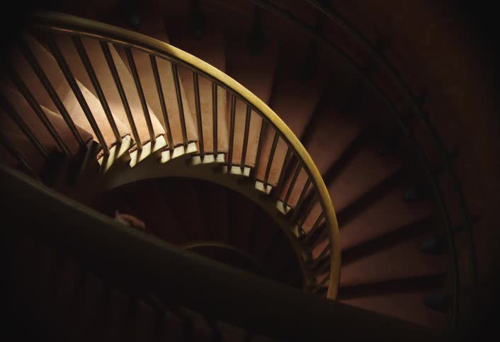 Two children one of them in a fairy costume descending a circular staircase
