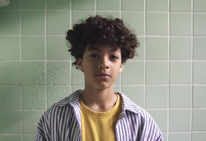 Boy with curly hair in an indoor space
