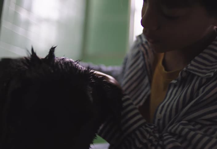 The child is in the bathroom giving his dog a bath