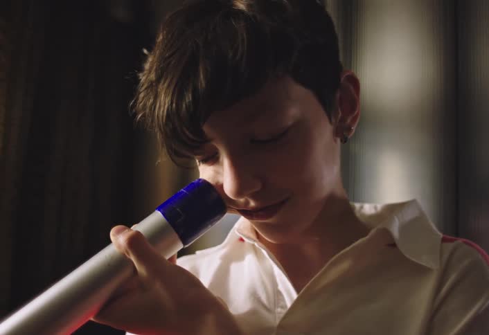 A child puts the vacuum on their cheek