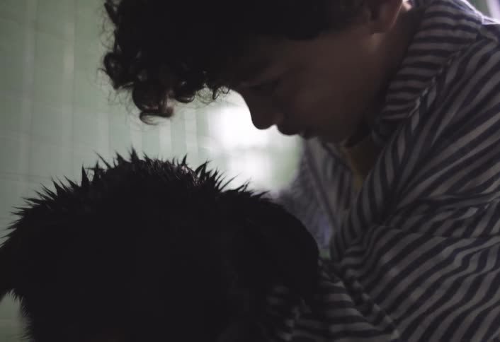 A boy is washing his dog