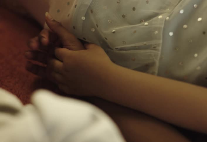 Two children lying down holding hands